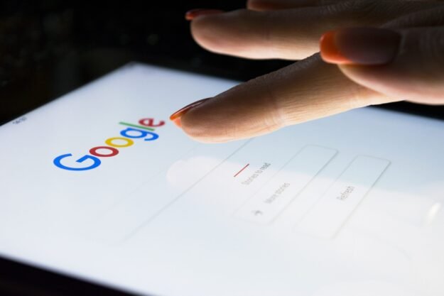 Sankt-Petersburg, Russia, November 8, 2017: A woman’s hand is touching screen on tablet computer iPad pro at night for searching on Google search engine. Google is popular Internet search engine